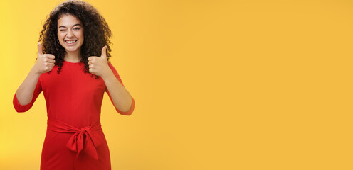 Creative and charismatic happy upbeat woman 25s with curly hair in red dress winking in approval...