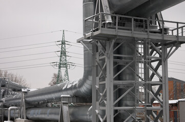 pipeline and power line in the city in winter against the gray sky.