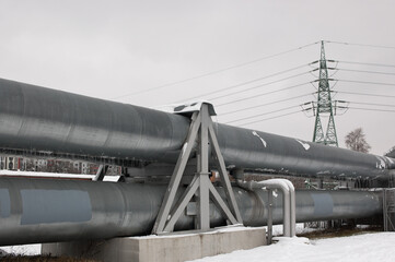 pipeline and power line in the city in winter against the gray sky.