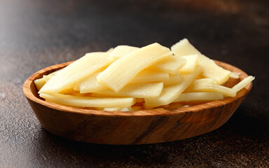 Sliced canned bamboo shoots in wooden bowl