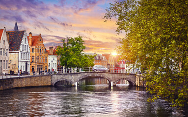 Fototapeta na wymiar Bruges Belgium. Old town with vintage houses and stone bridge on the river sunset sky. Picturesque landmark in Europe
