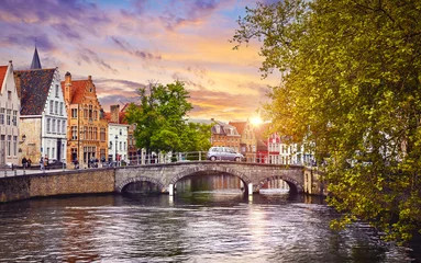 Photo sur Plexiglas Brugges Bruges Belgium. Old town with vintage houses and stone bridge on the river sunset sky. Picturesque landmark in Europe