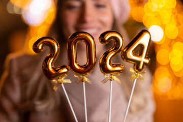 Young woman holding 2024 number for new year eve