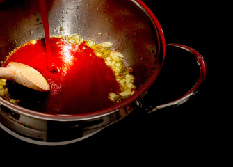 frying onions in a pot with the addition of ketchup