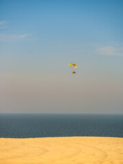 A Powered paraglider above Doha sand dunes in Doha, Qatar