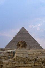 The Sphinx seen from the front, with Khaphren's pyramid just behind, with the sky full of clouds