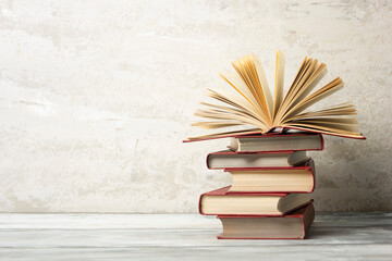Vintage old hardback books, diary, fanned pages on wooden desk table and grunge background Daylight. Books stacking. Back to school. Copy Space. Education background