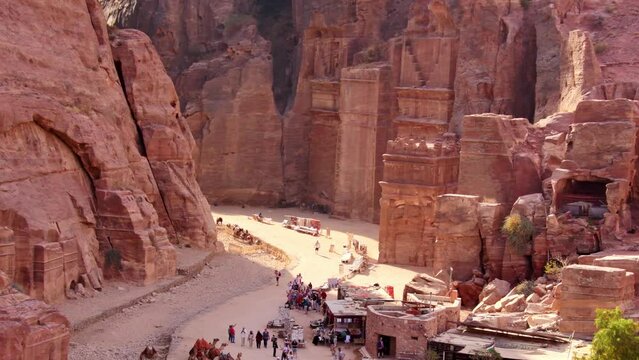 Top view tourist visit sightseeing Royal tombs structures in ancient city of Petra, Jordan. It is know as the Loculi. Petra has led to its designation as UNESCO World Heritage Site