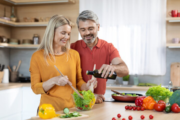 Good-looking spouses preparing healthy vegetable salad at home, copy space