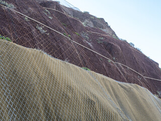 Slope netting for enhancing slope stabilization