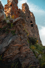 The surviving stone walls of an ancient ruined castle in the mountains against the sky. Historical architectural monument.
