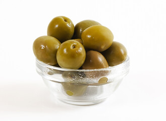 Green olives in a glass container. Shallow depth of field	