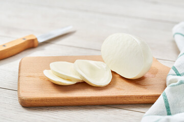 sliced Italian cheese mozzarella buffalo on a white kitchen table,with copy space for text.