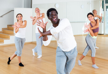 Positive aframerican man enjoying active dances in modern dance studio.