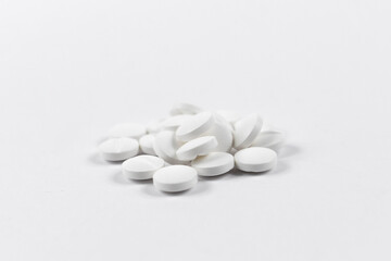 Fototapeta na wymiar many white round medical tablets for humans and animals, medicinal antibiotics pills medicine closeup