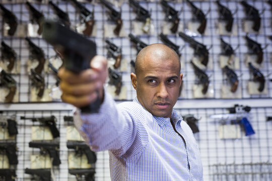 Portrait of male customer which is choosing pistol in army market
