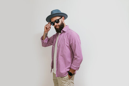 Fashion portrait of a young bearded hipster man. Handsome man in a hat isolated on white background.
