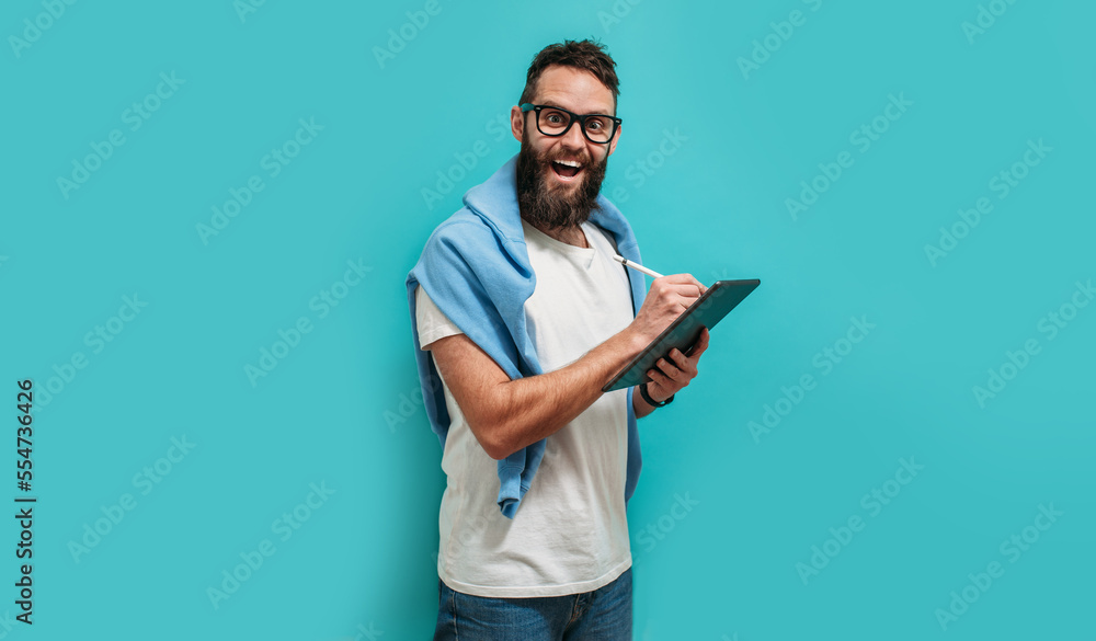 Fototapete Professional designer working on digital tablet computer using stylus pen isolated over blue color background.