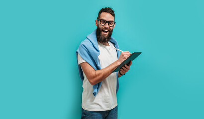 Professional designer working on digital tablet computer using stylus pen isolated over blue color...