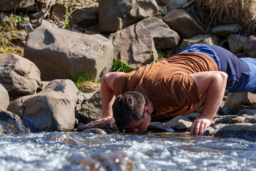 man drinking pure river water in iceland