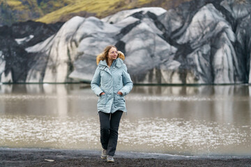 woman on the shore of a glacier lagoon enjoying nature in iceland