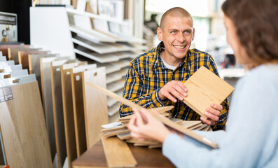 Man and woman chooses laminate flooring in hardware store