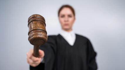 Steadfast female judge in a robe holding a court gavel. 