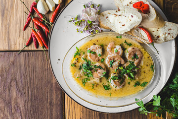Prawns in hot sauce served with buttered bread on a white plate. Dish for seafood lovers. High angle view. High quality photo