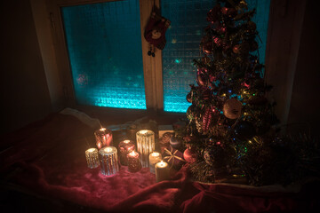 Festive background. Christmas decorations. Santa Claus (or Snowman) standing on snow with beautiful decorated background with holiday elements. Selective focus. Empty space for your text