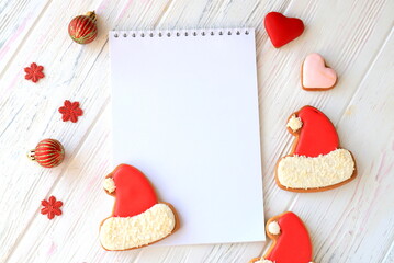 New Year background 2023 White notebook for Christmas wishes, goals, recipes, plan, start for new year among gingerbread cookies