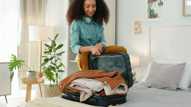 Travel, bedroom or happy black woman with suitcase or luggage for clothes at a airbnb or hotel room for a holiday. Smile, freedom or girl packing bags for a relaxing solo trip vacation or adventure