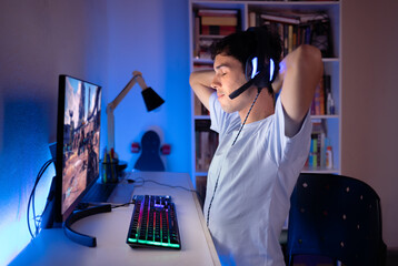 Young man playing online  games on his computer.  Voice chatting through headset