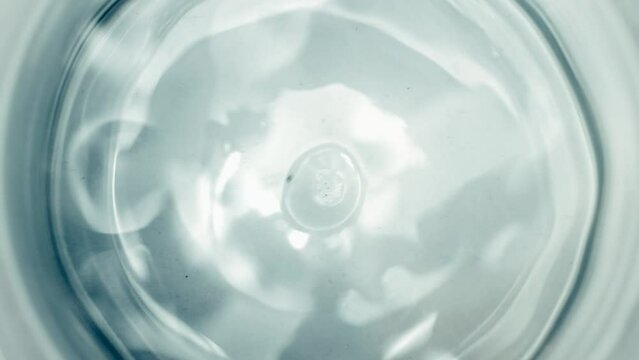 Pure Water Poured Into Glass closeup on light gray background. Super slow motion. Quenching thirst concept. Clear fresh drinking water filling glass close up