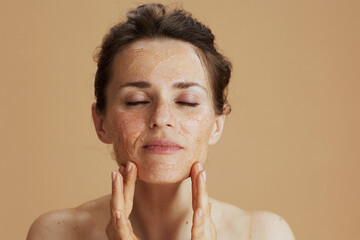 modern woman with face scrub isolated on beige