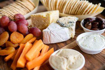 Cheese platter with grapes, biscuits and carrots