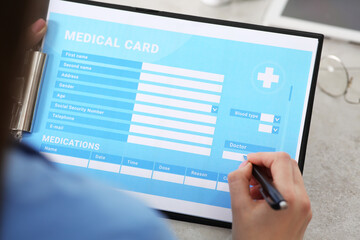 Doctor filling patient's medical card in clinic, closeup