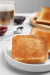 Slices of tasty toasted bread on white table, closeup