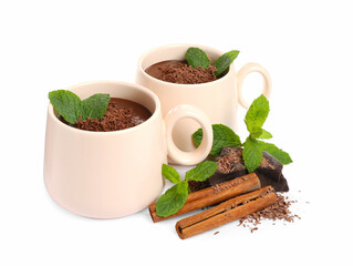 Cups of delicious hot chocolate with mint and cinnamon sticks on white background