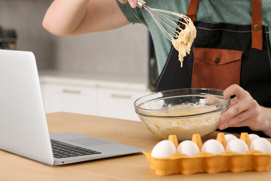 Man learning to cook with online video at wooden table in kitchen, closeup. Time for hobby