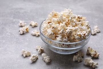 Bowl of tasty popcorn on grey table, space for text