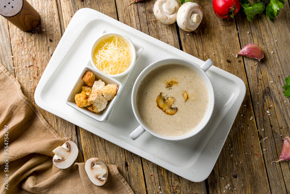 Wall mural Cream soup of mushrooms on wooden table top view