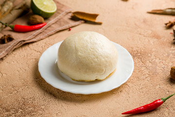 Bao bun on plate on brown table