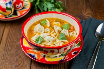 Dumplings in the soup chuchvara Uzbek cuisine on wooden table