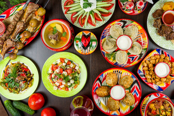 Fototapeta na wymiar dishes of Uzbek cuisine lagman, pilaf, manti, kazan kebab, salad,skewers and shurpa top view