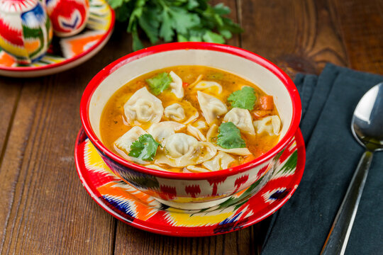 Dumplings in the soup chuchvara Uzbek cuisine on wooden table
