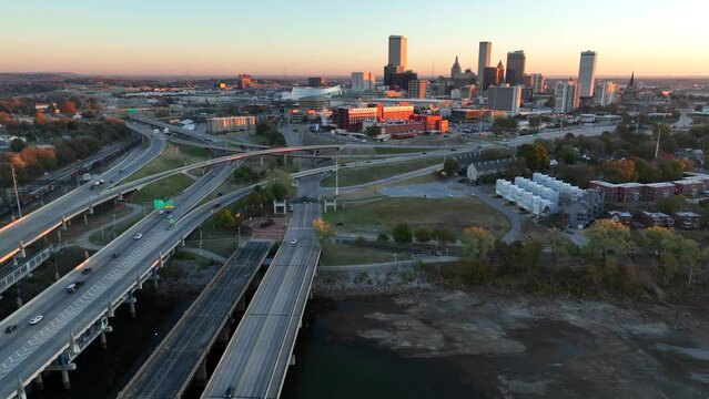 Riverbank of Arkansas River and aerial truck shot with Tulsa skyline at dawn.