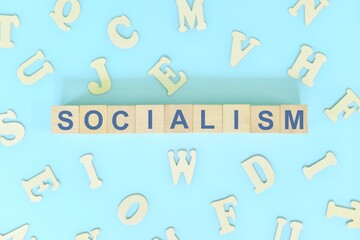Socialism government form concept. Wooden blocks typography flat lay in blue background.	