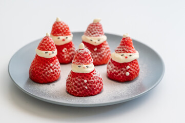 Several Santas made of strawberries lie on a plate
