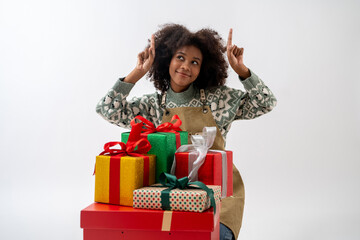 Portrait of young attractive african american woman with curly hair presenting gift boxes in studio...
