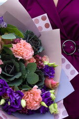 Big luxury bouquet of purple flowers in woman hands